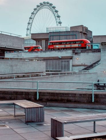 National Theatre exterior looking west with London buses crossing Waterloo Bridge