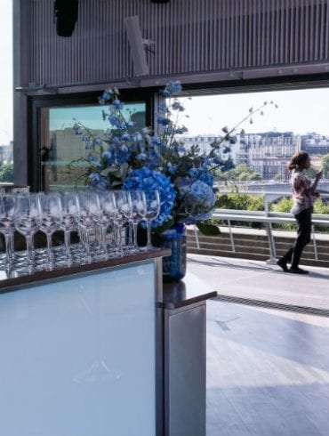 The Buffini Chao Deck event hire space - view from interior with bar and flowers, looking north to Somerset House