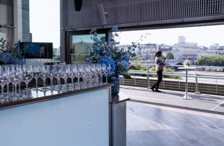The Buffini Chao Deck event hire space - view from interior with bar and flowers, looking north to Somerset House