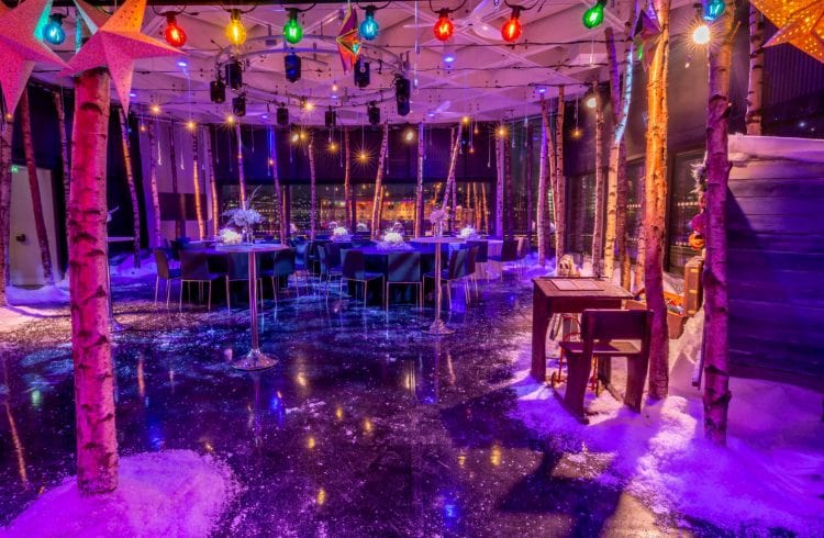 Christmas theme of birch trees and snow with tables and coloured lights