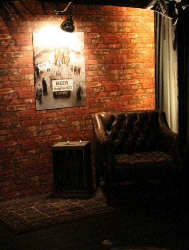 A Speakeasy Christmas design with illuminated sign and leather chair