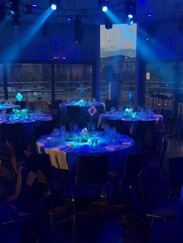 Tables set for dinner with blue themed lighting effects