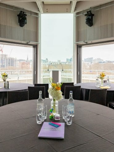 The Buffini Chao Deck event hire space: conference setup with table seating and lectern