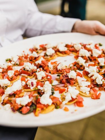 A white platter of canapes being held by a waiter